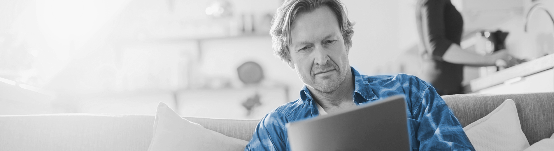 Foto man met blauwe blouse achter laptop op de bank